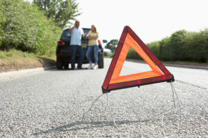 Couple Broken Down On Country Road With Hazard Warning Sign In F