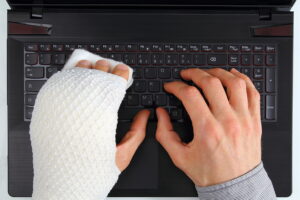 Working On A Notebook With Hand Injury